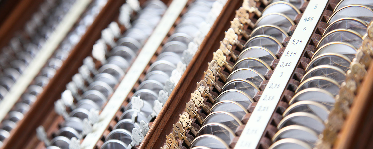 Sammlung von antiken optischen Linsen in einem Holzregal